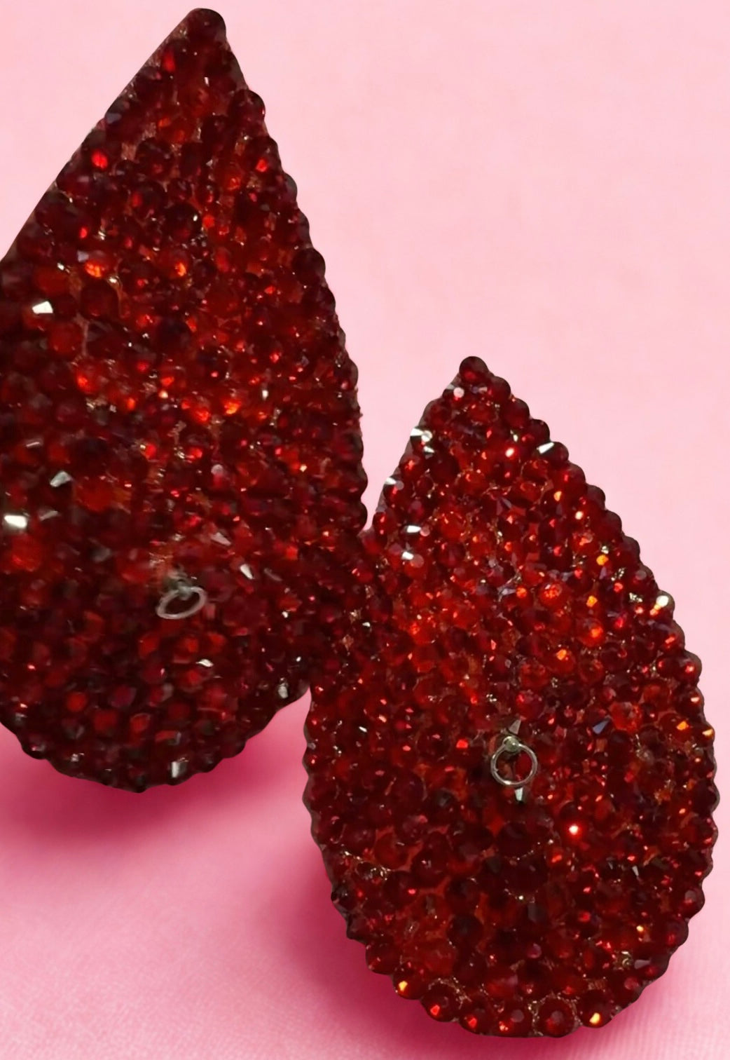 Viva La Bombshell Burlesque Teardrop Pasties shimmer in red rhinestones on a soft pink background. Reusable and textured with faceted stones, these pasties add elegant shine for a dazzling statement.