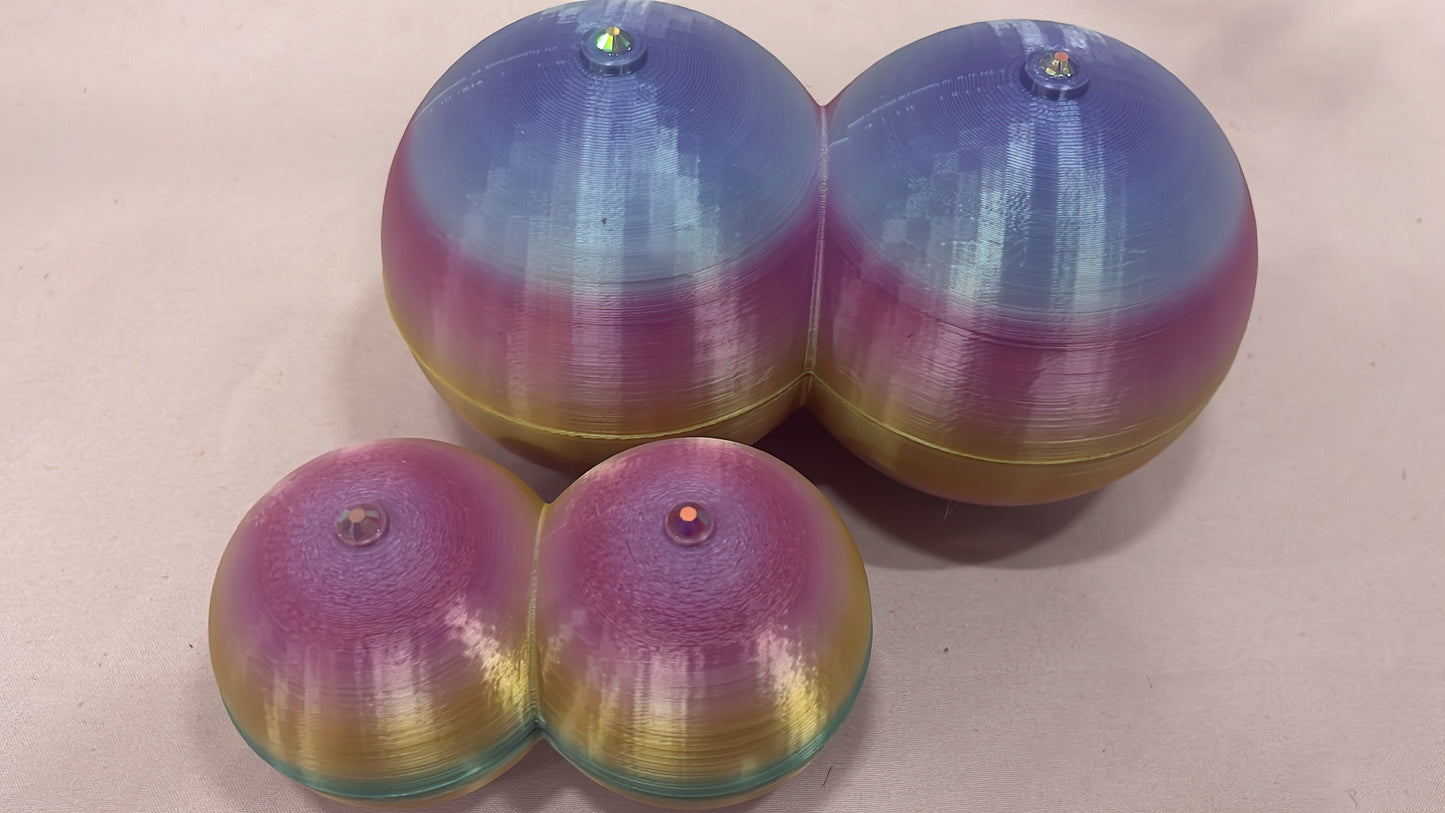 Four round, dome-shaped Boobie Boxes by Viva La Bombshell Burlesque in gradient hues—blue, purple, pink, yellow, and teal—feature gem-like beads on top. Stylish 3D-printed storage for pasties, shown in pairs on a light background.