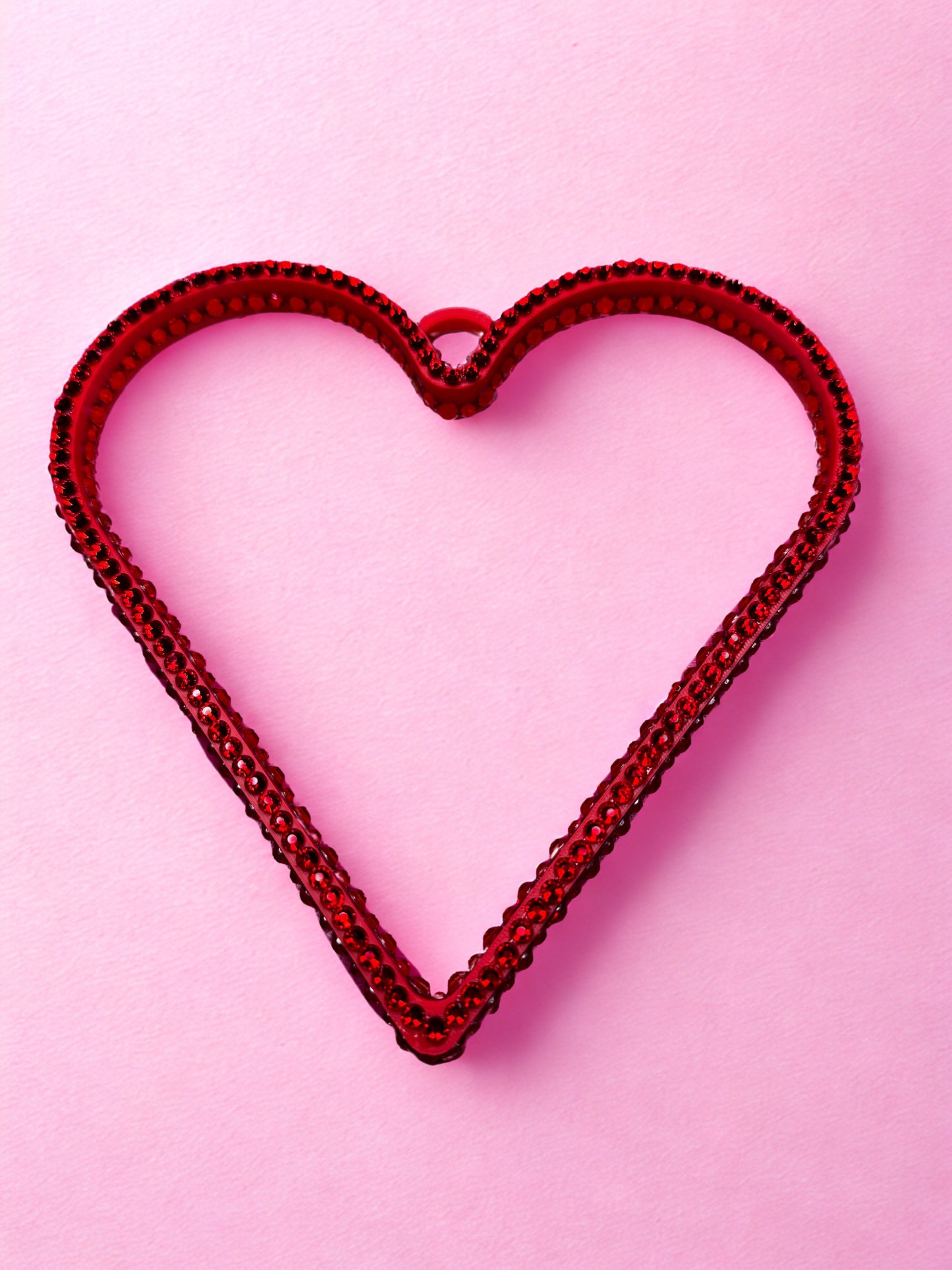 Red heart-shaped boa bangle on a pink background