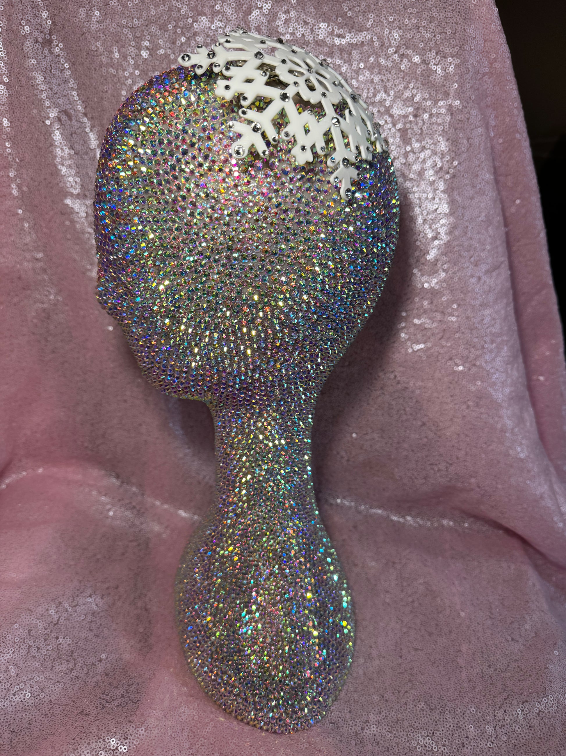The Snow Queen Fascinator by Viva La Bombshell Burlesque crowns a rhinestone-studded mannequin head, set against shimmery pink fabric for a dazzling display.