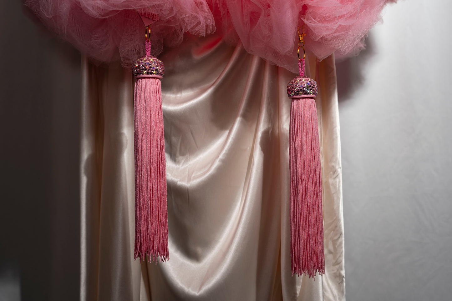 The Dazzle - Tulle Boa by Viva La Bombshell Burlesque features pink tassel toppers perfect for adding flair to your curtains.