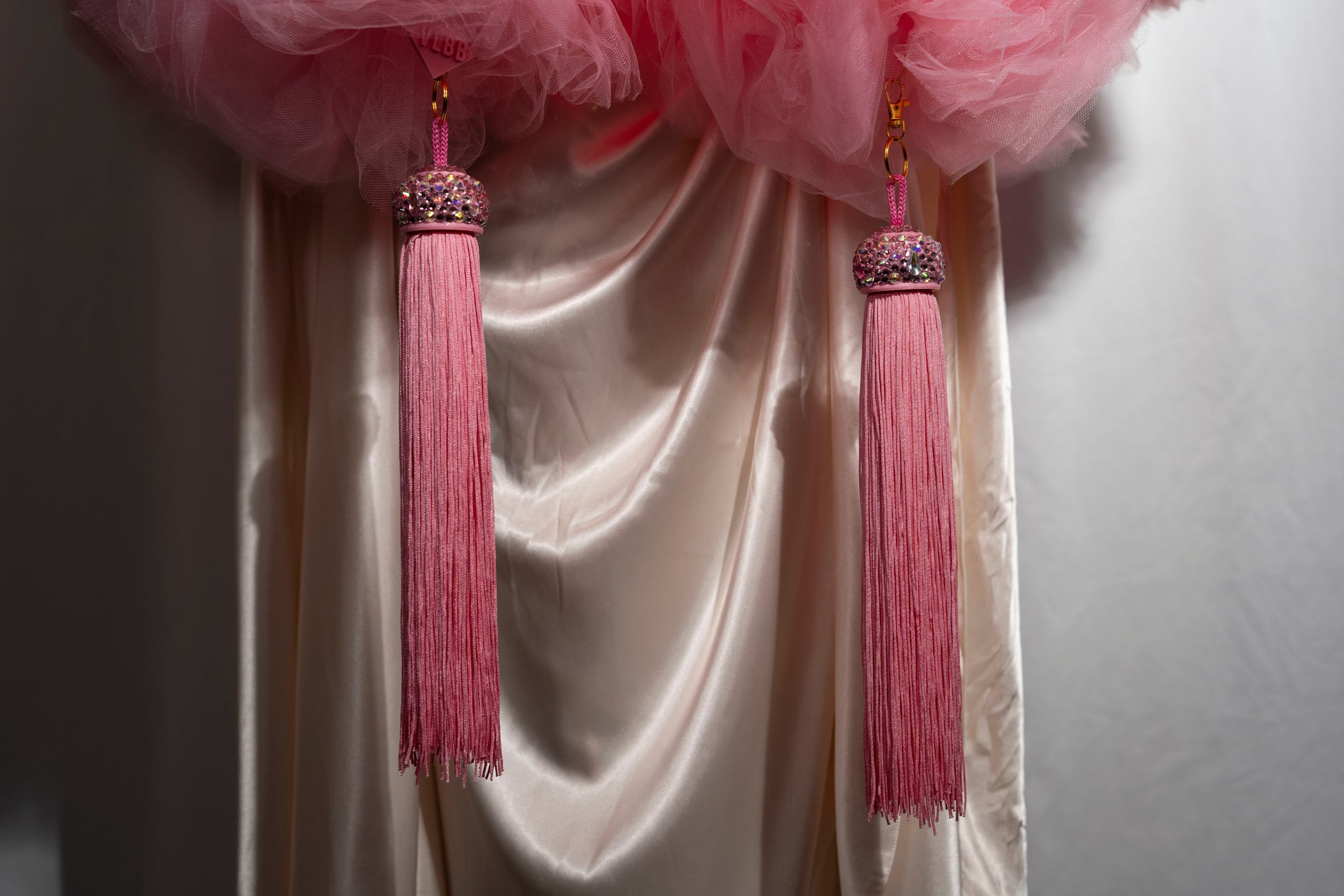 The Dazzle - Tulle Boa by Viva La Bombshell Burlesque features pink tassel toppers perfect for adding flair to your curtains.