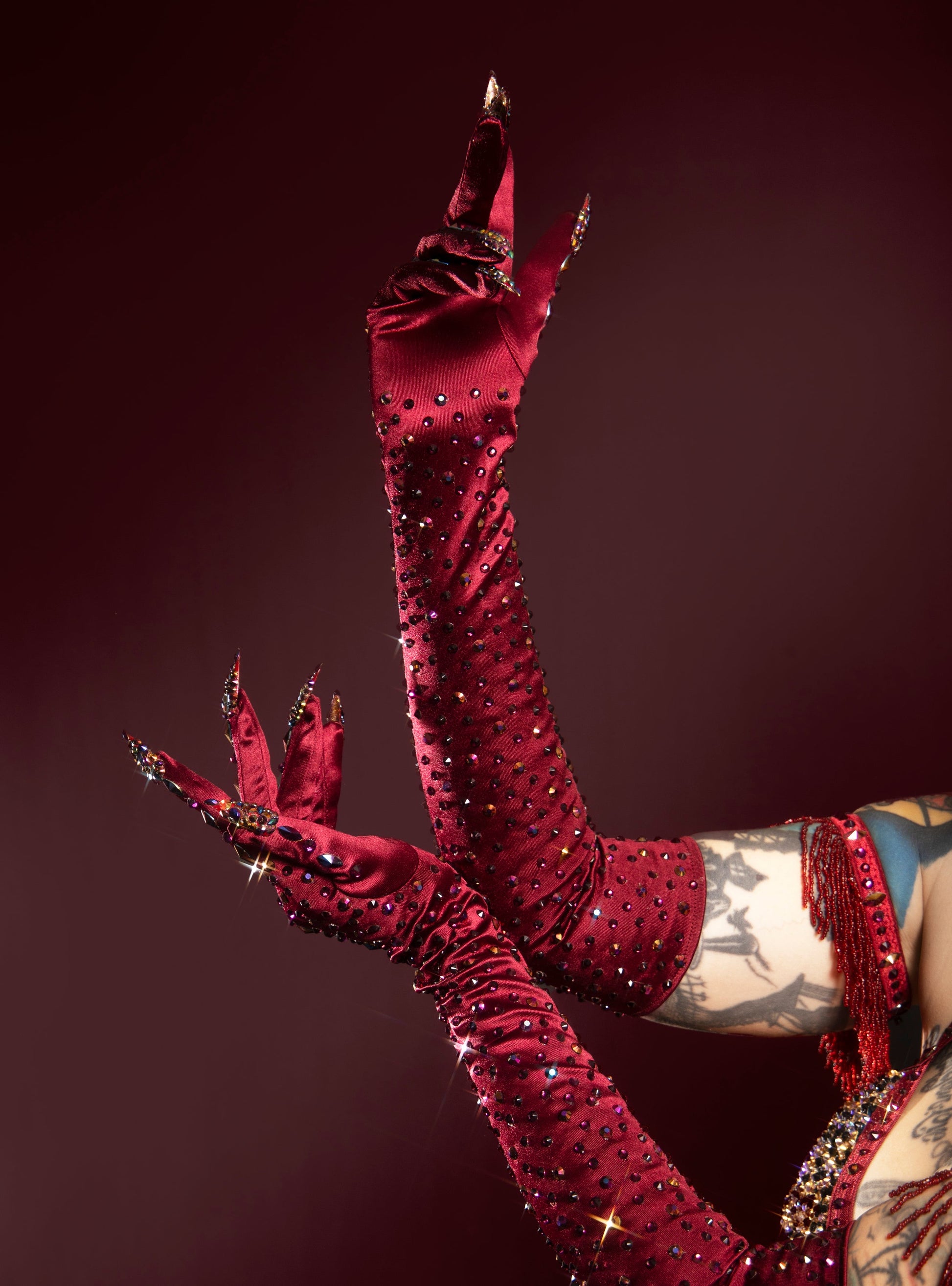 burgundy, ornate gloves with intricate designs against a dark background