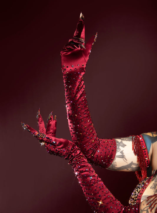 burgundy, ornate gloves with intricate designs against a dark background
