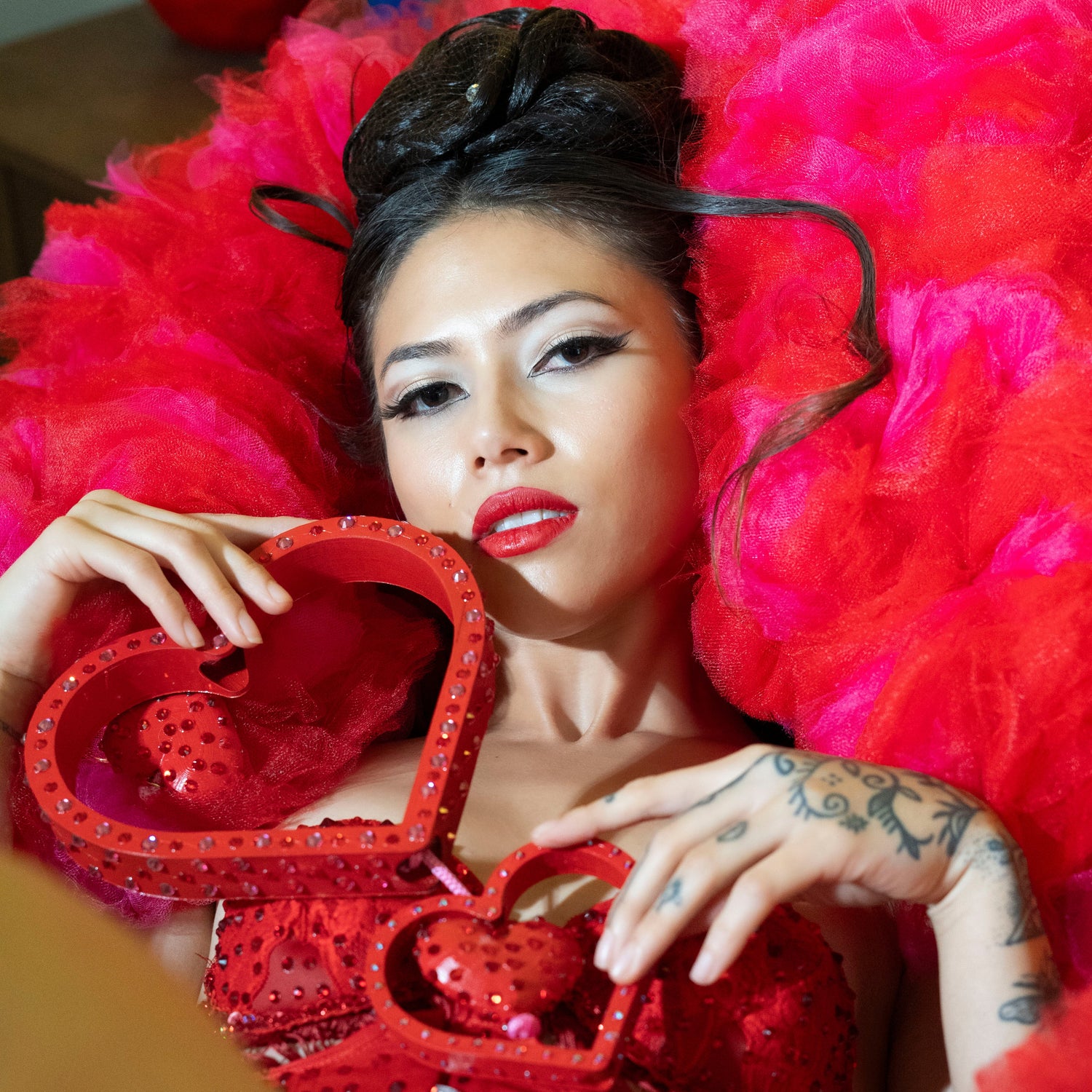 Meilani Venus laying on a pink and red tulle boa with 3D printed heart boa attachments 