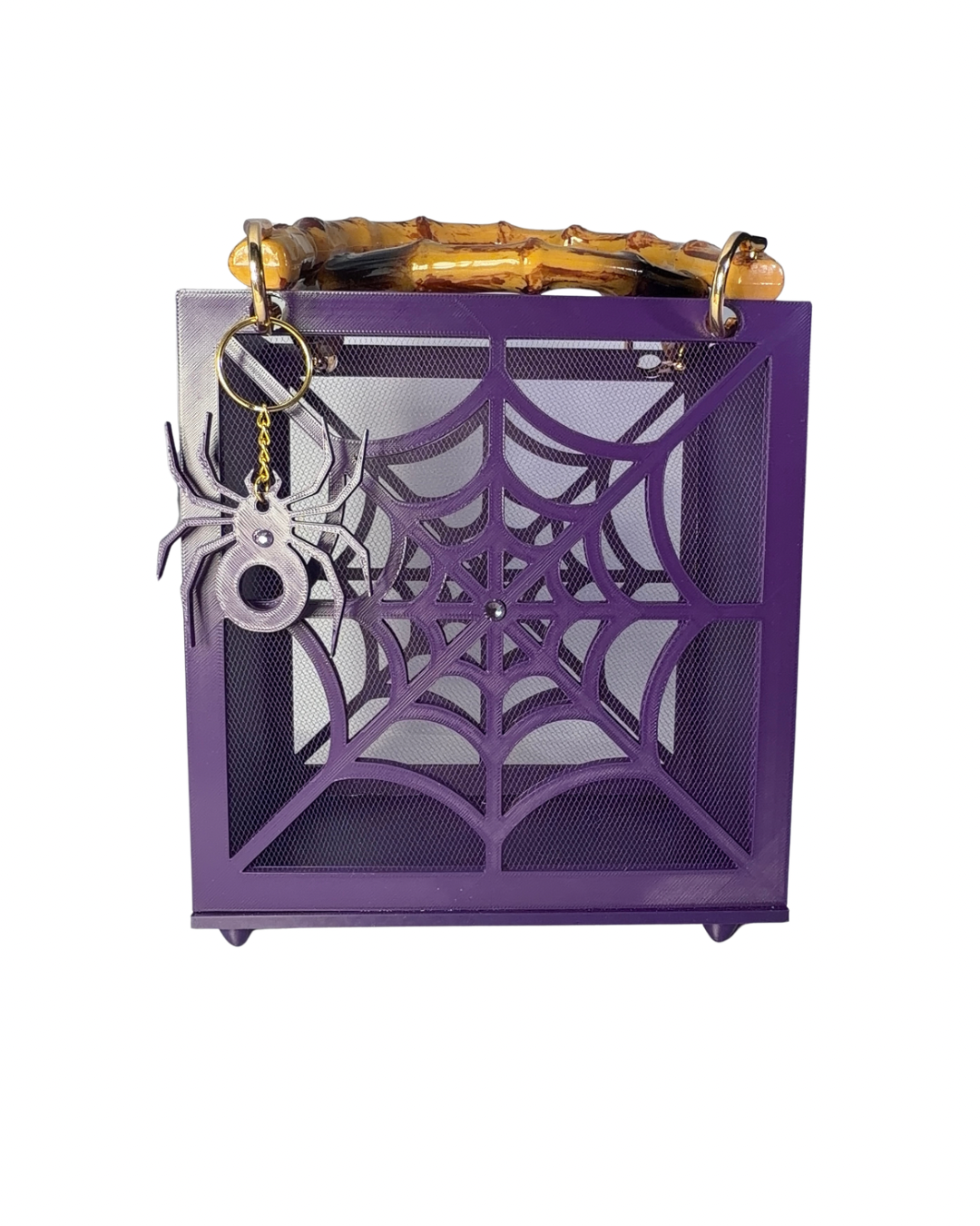 Introducing The Widow – Spiderweb Purse by Viva La Bombshell Burlesque: a purple, box-shaped handbag adorned with a striking spiderweb design, mesh panels, elegant bamboo handles, and finished with a charming spider keychain attached to the top corner.