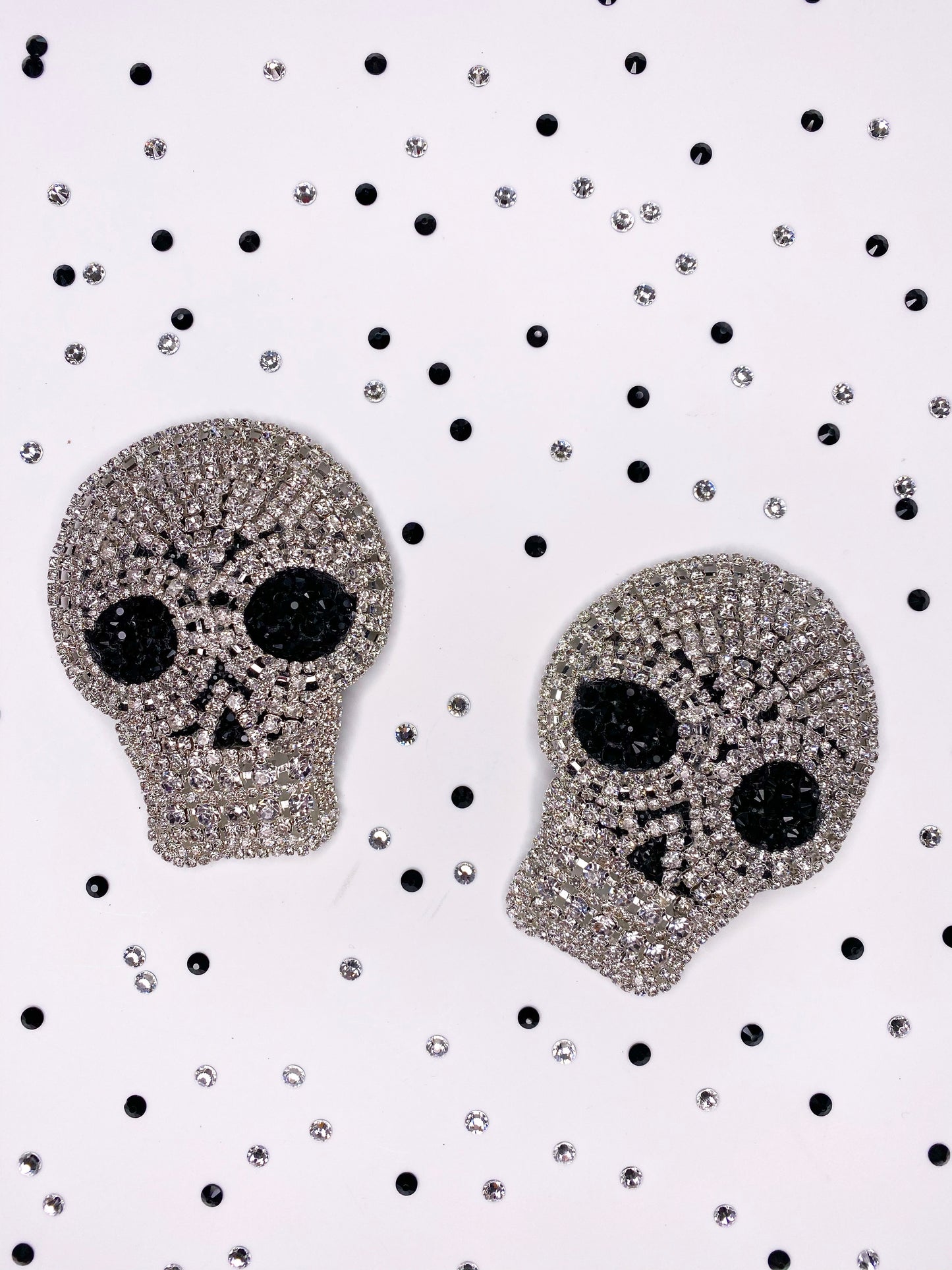 A pair of clear rhinestone skull applique with black rhinestone eyes pasties 