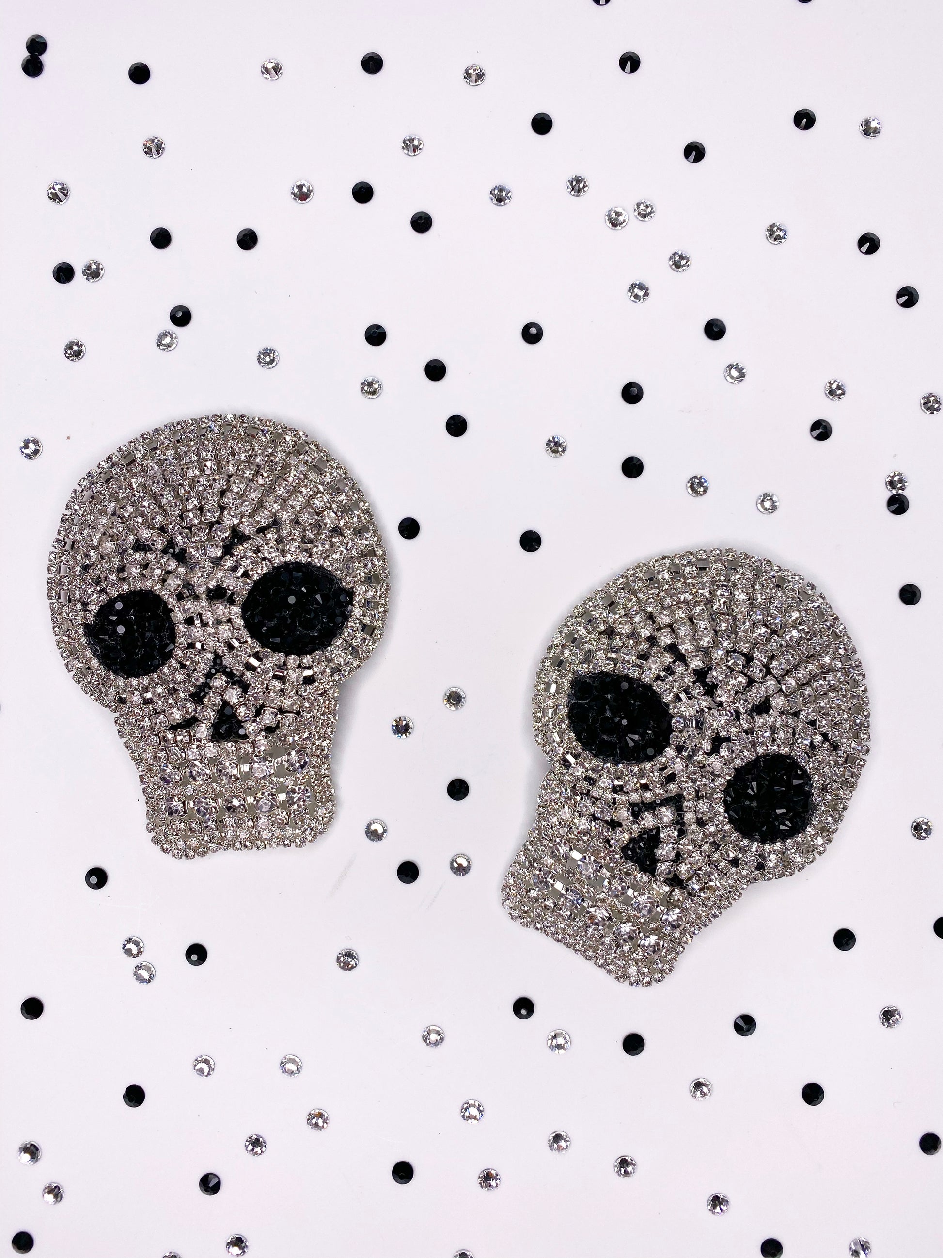 A pair of clear rhinestone skull applique with black rhinestone eyes pasties 
