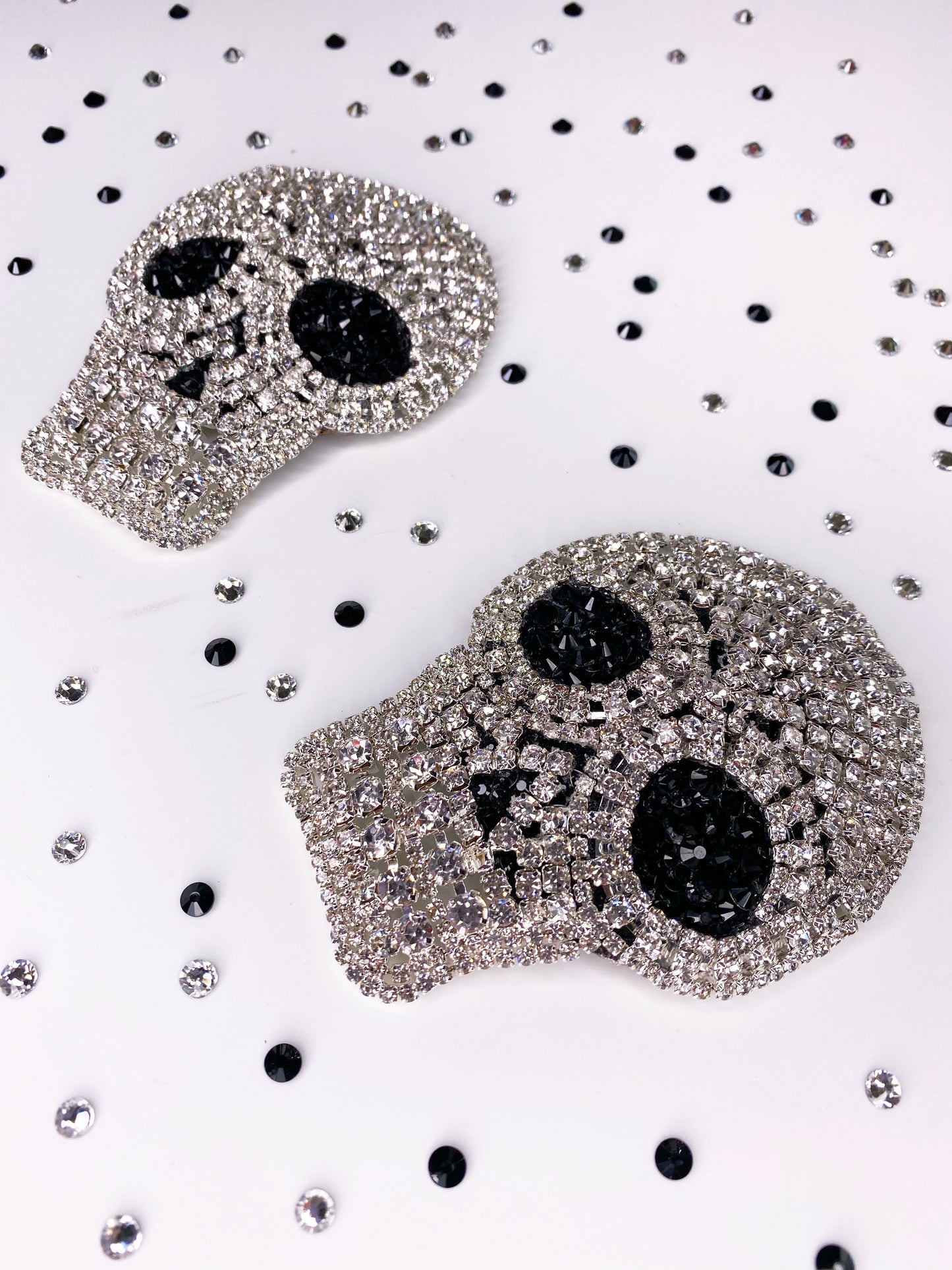 A close up of clear rhinestone skull applique with black rhinestone eyes pasties 