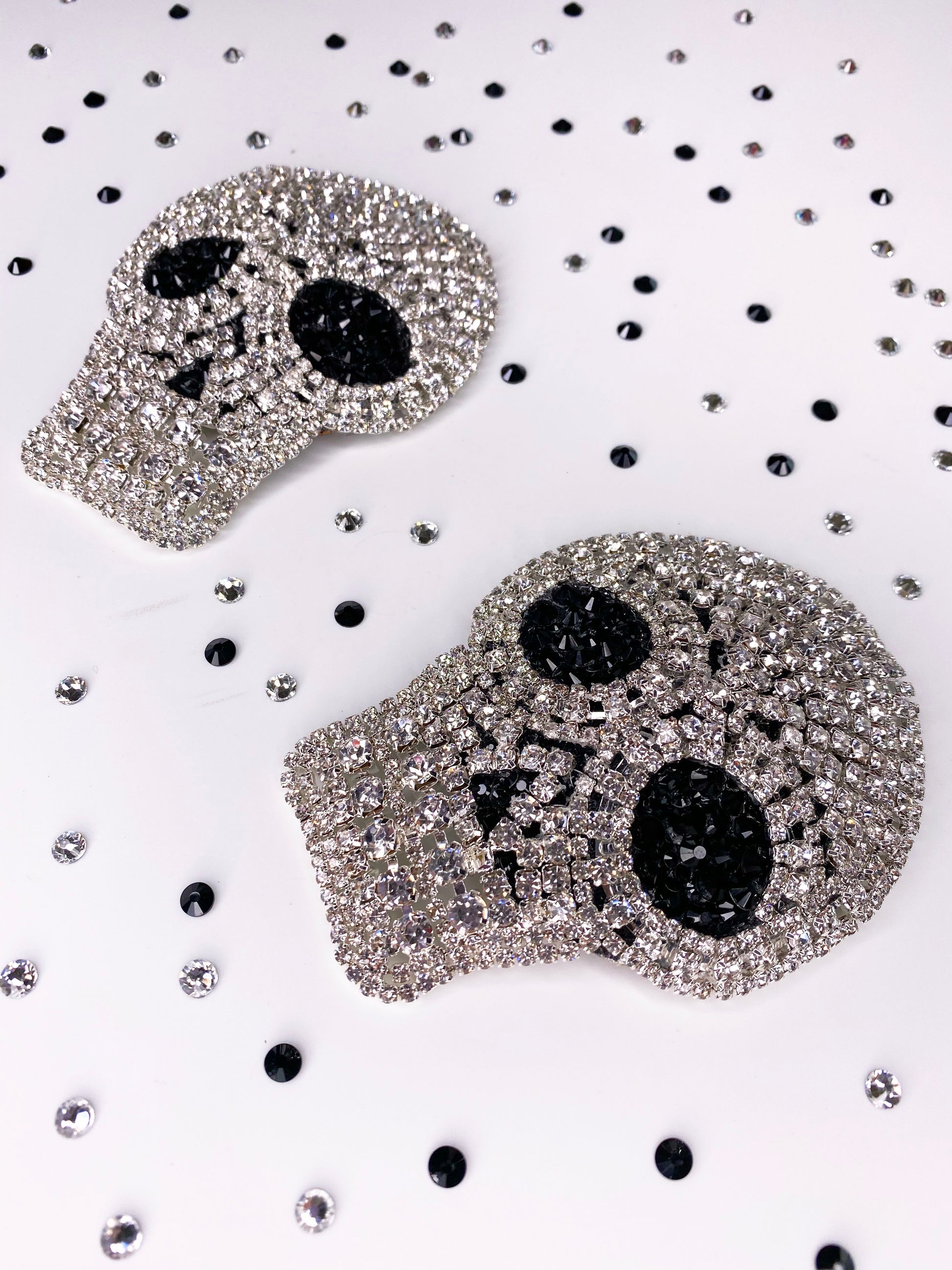 A close up of clear rhinestone skull applique with black rhinestone eyes pasties 
