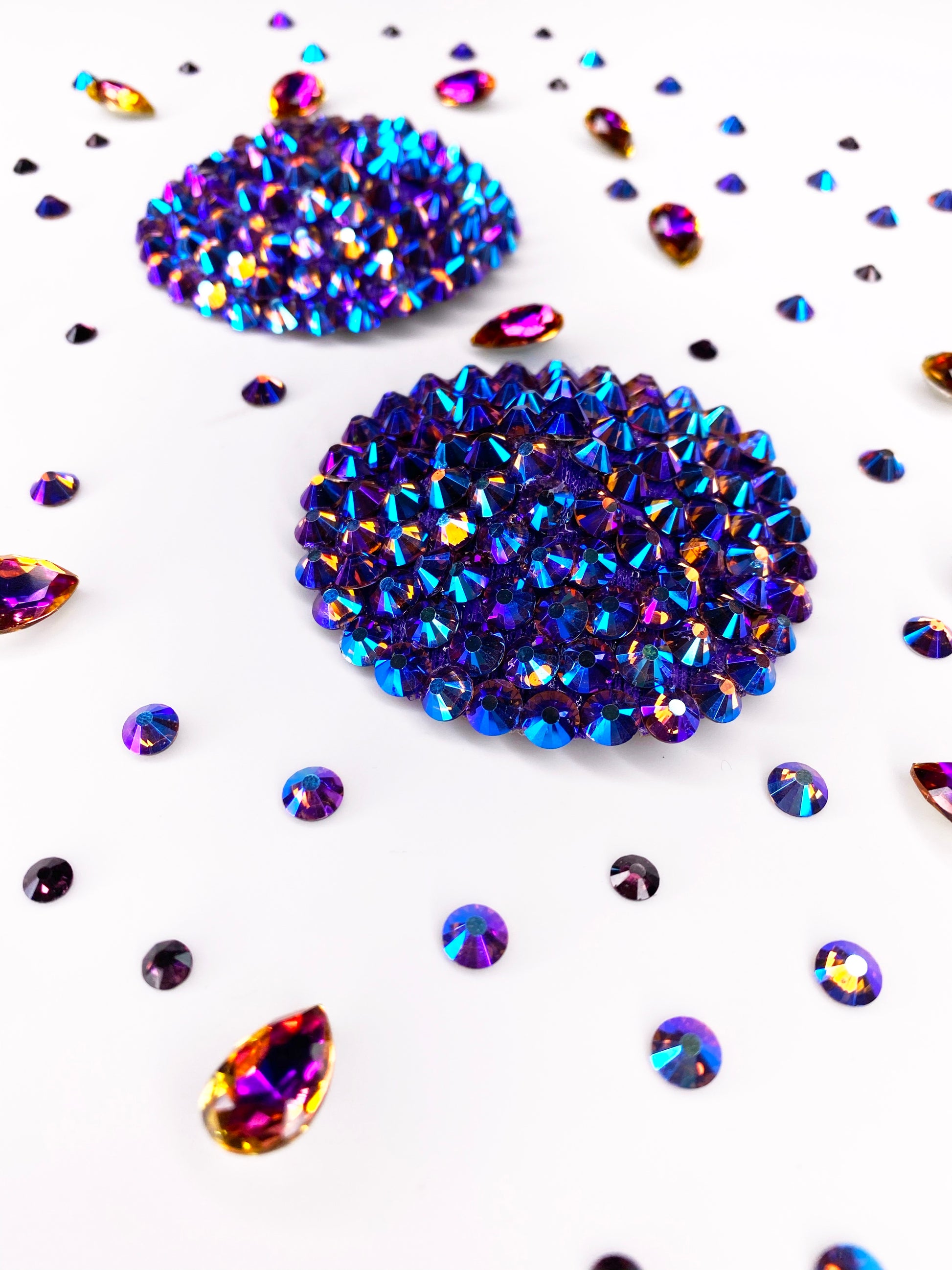 The Simple Rhinestone Pasties (Circle) by Viva La Bombshell Burlesque feature large blue-purple rhinestone clusters accented with smaller colorful gems, all displayed on a white background.
