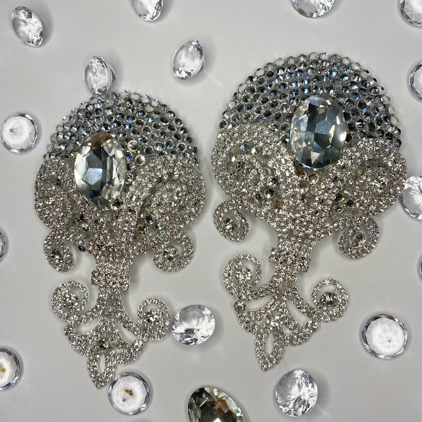 The Viva La Bombshell Burlesque Showstopper Pasties feature ornate silver jeweled designs with large central gems and crystal rhinestones, surrounded by clear gemstones on a light gray background.