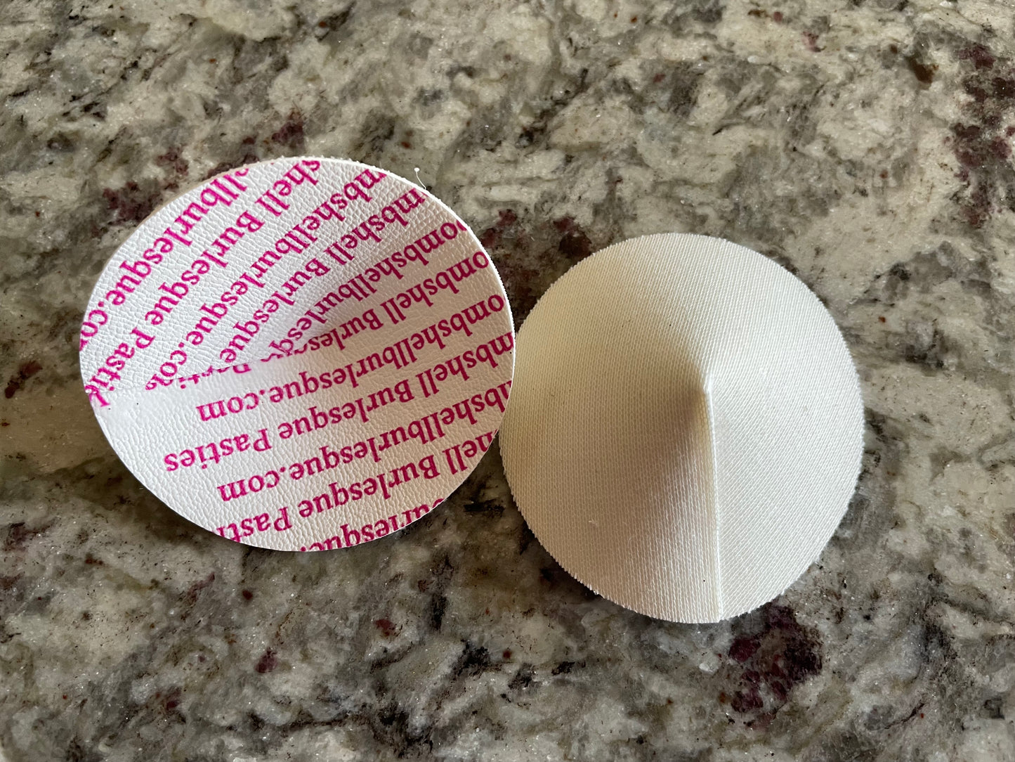 Two round fabric pads from Viva La Bombshell Burlesque sit on a granite countertop; these are DIY Pastie Bases (Plain Bases), ideal for creating custom tassel twirler accessories.
